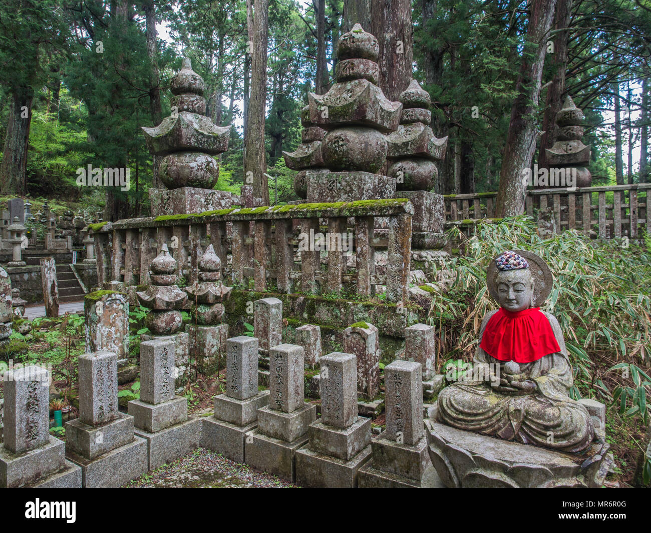 Statue Jizo Bosatsu avec dossard rouge, et cinq niveaux gorinto stupas, et pierres tombales memorial, Okunoin, Koya-san, préfecture de Wakayama, Japon Banque D'Images