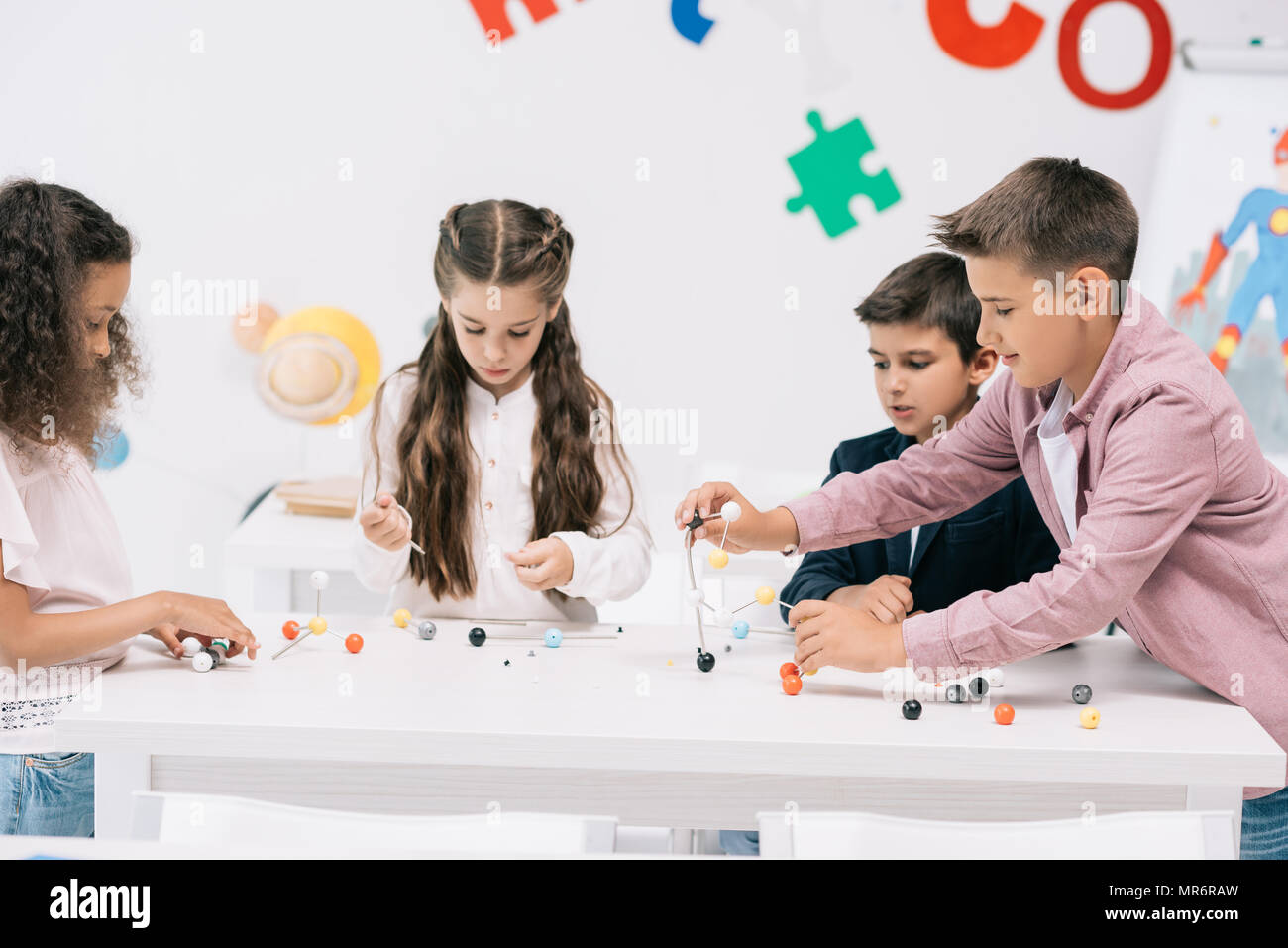 Groupe multiethnique d'écoliers étudient avec le modèle moléculaire au cours de chimie Banque D'Images