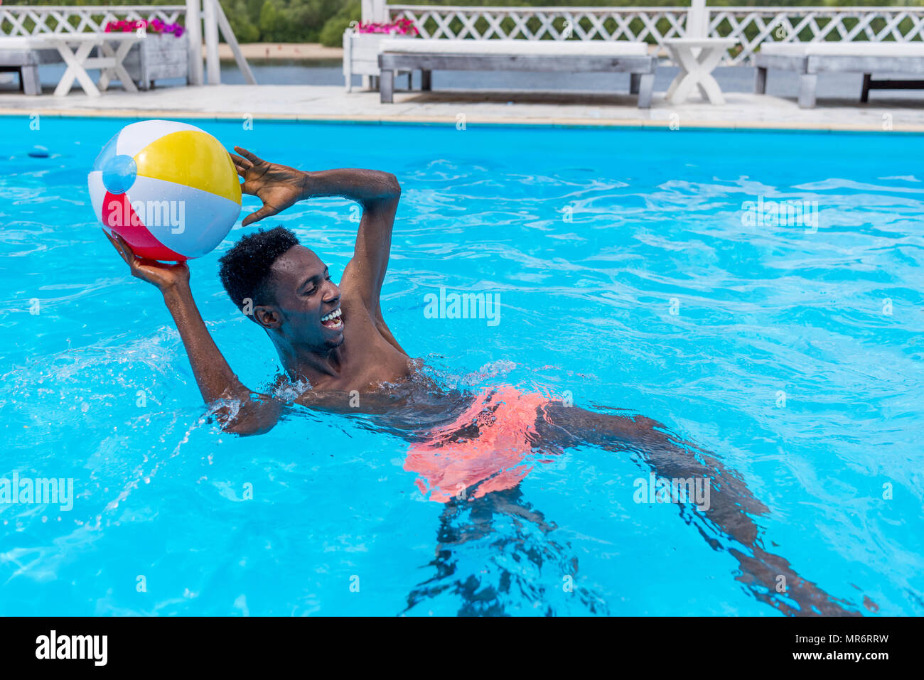 Young happy african american man Playing with ball in swimming pool Photo  Stock - Alamy