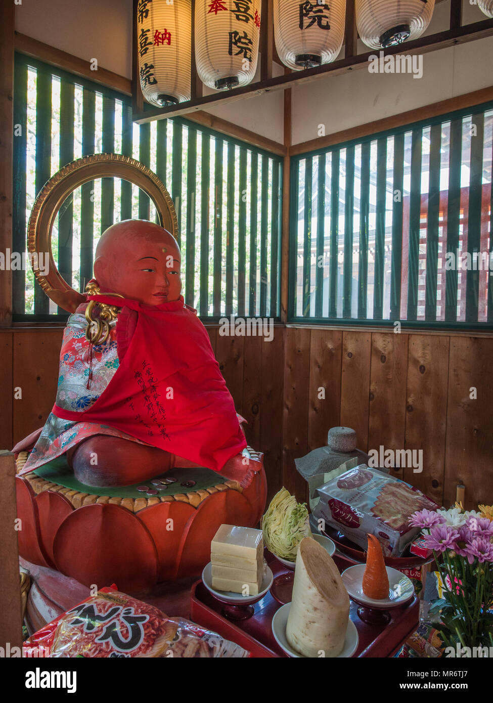 Statue Jizo Bosatsu avec dossard rouge et les offrandes, Koyasan, Wakayama, Japon Banque D'Images
