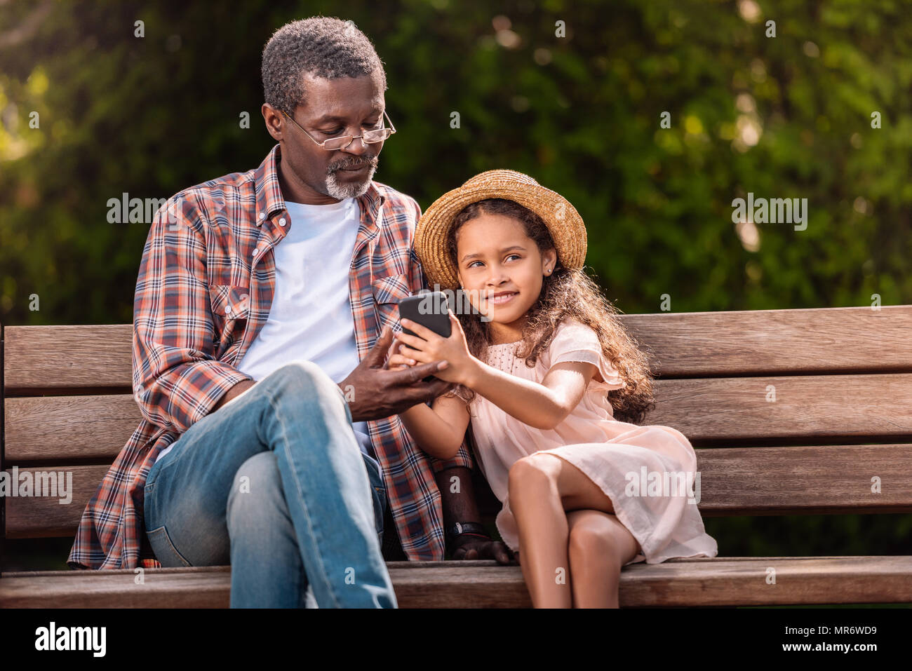 Smiling african american girl et son grand-père à l'aide de smartphones ensemble Banque D'Images