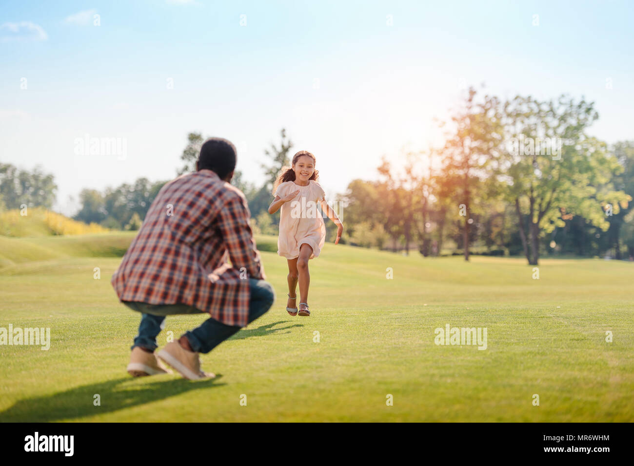 Happy african american petite-fille courir à grand-père sur pelouse verte dans la région de park Banque D'Images