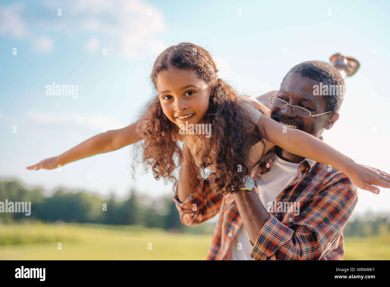 Smiling african american grand-père jouant avec sa petite-fille de sunny day Banque D'Images