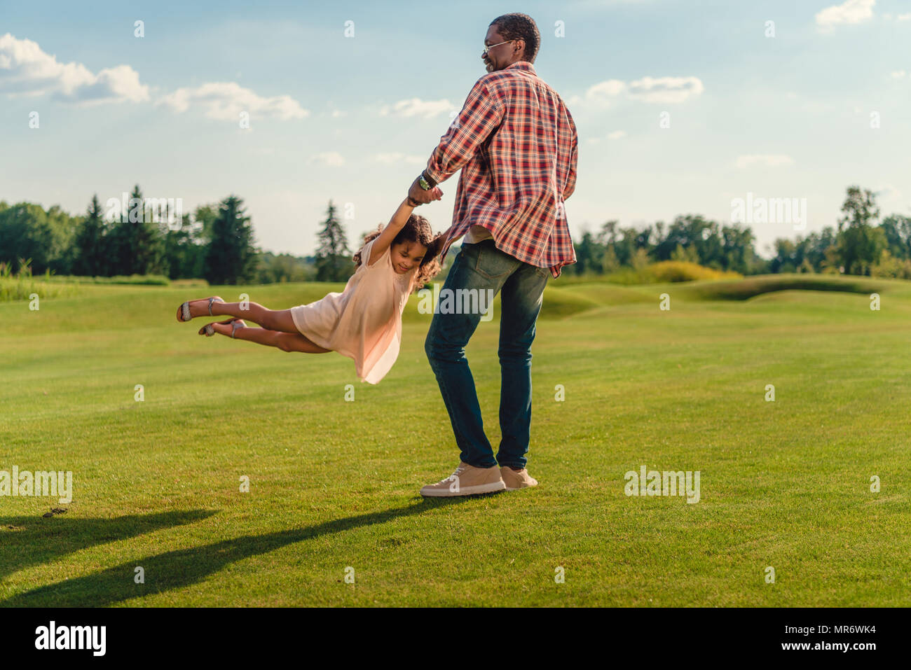 Happy african american grand-père jouant avec sa petite-fille sur pelouse verte Banque D'Images