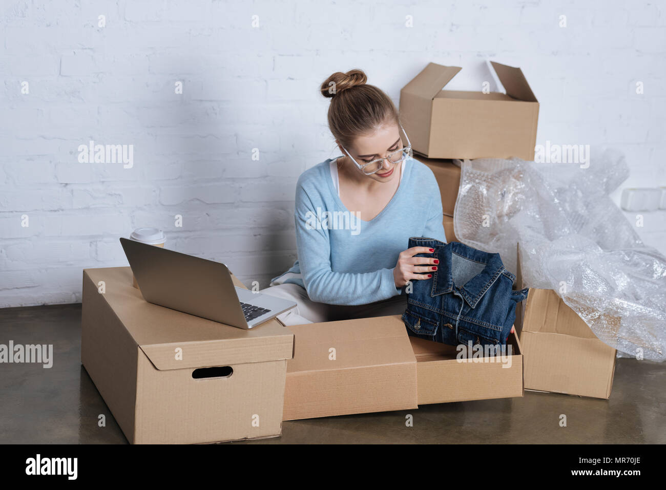 Veste en jean jeune entrepreneur de mettre en boîte en carton d'emballage  et produits au bureau à domicile Photo Stock - Alamy