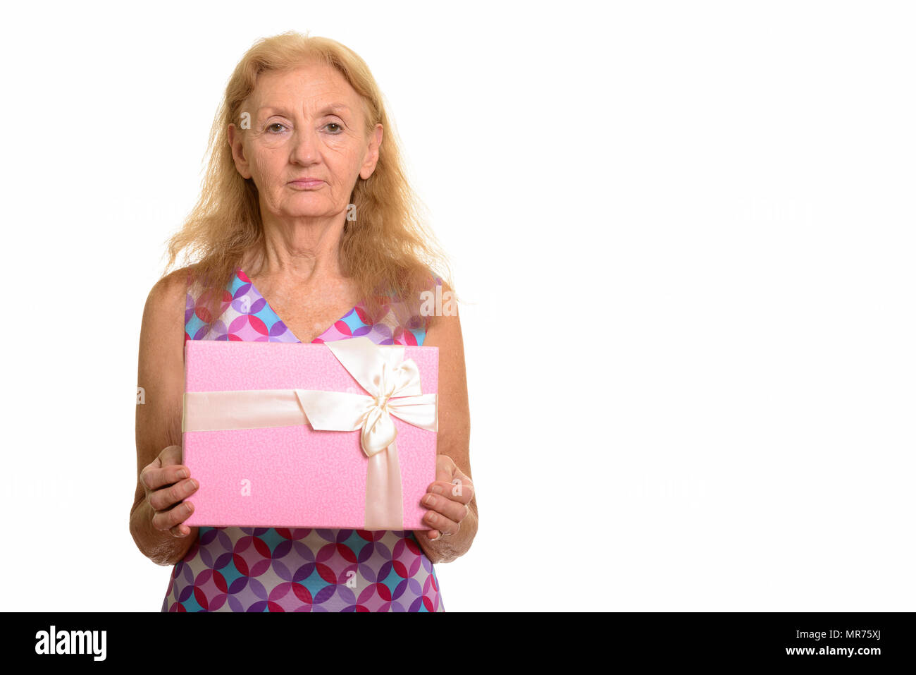 Studio shot of senior woman holding gift box Banque D'Images