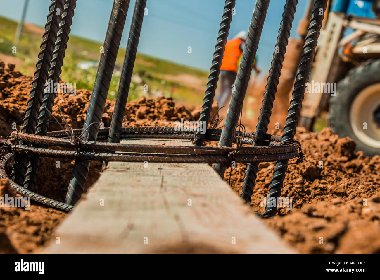 Barre d'acier utilisé pour la construction des poteaux avec renforcement du béton dans un trou dans le sol au chantier de construction. Banque D'Images