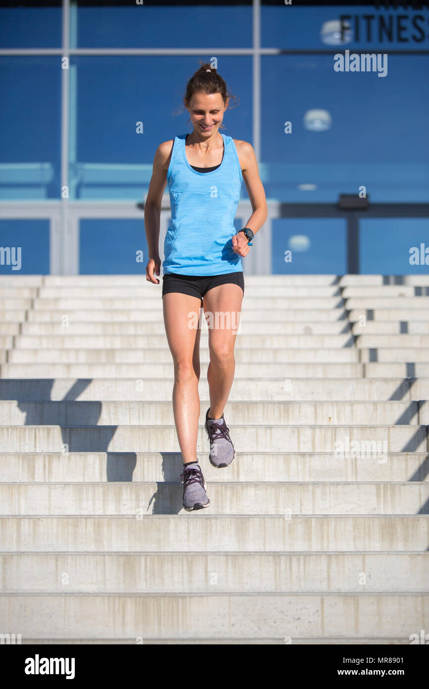Femme athlète courir dans les escaliers Banque D'Images