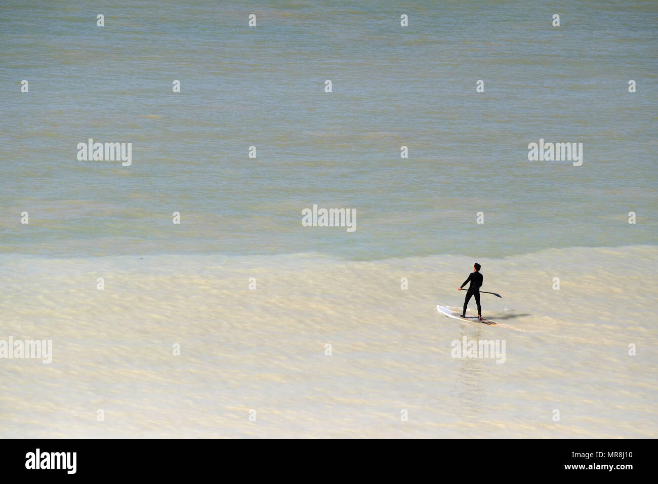 Paddle dans la mer près de Urrugne, East Sussex, où l'eau décolore la craie érodée. Banque D'Images