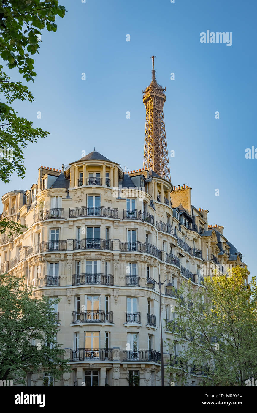 Paris typique immeuble dans la lumière dorée du coucher de soleil avec la Tour Eiffel en arrière-plan. Banque D'Images