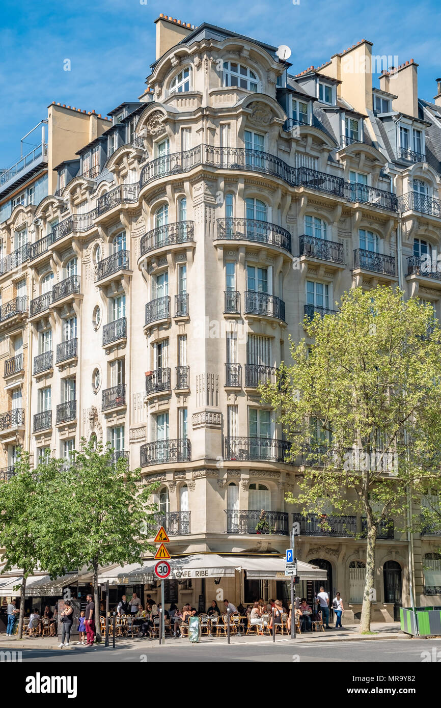 Un immeuble typique de Paris avec des détails complexes et fer forgé avec un petit café qui occupent le rez-de-chaussée. Banque D'Images