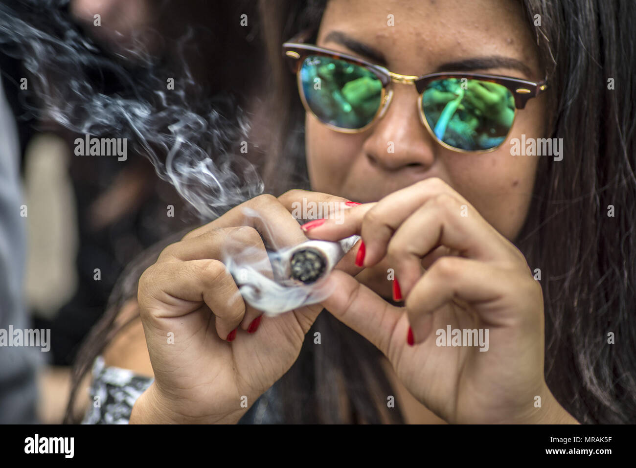 Sao Paulo, Brésil. 26 mai, 2018. Fille fume un joint énorme en tant que  militants exigent la légalisation de la marijuana depuis mars le Reichstag  pendant la parade annuelle du chanvre (Hanfparade).