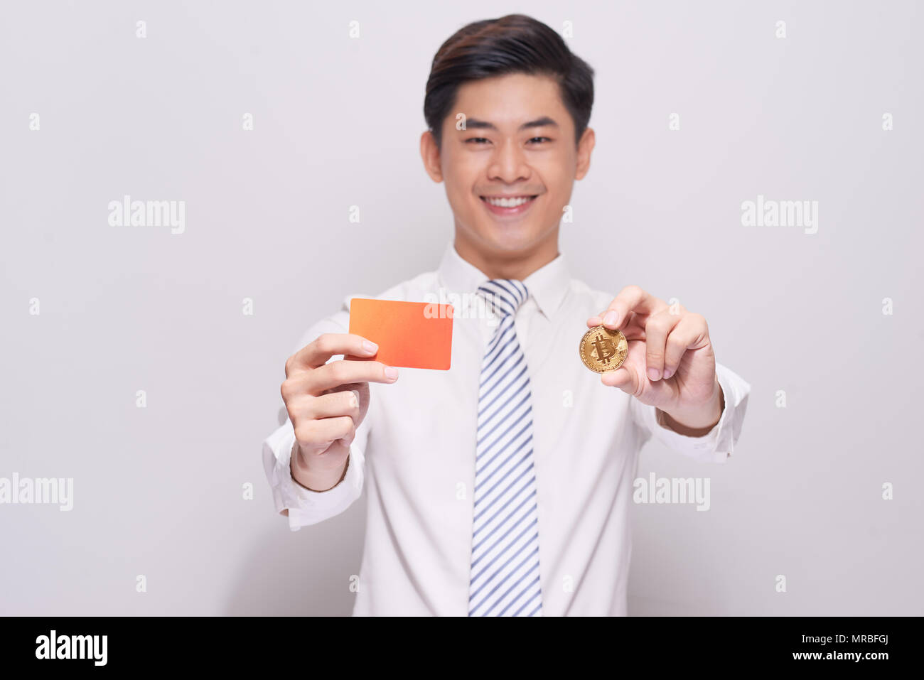 Young Man Holding Blank bitcoin et carte de visite sur fond blanc Banque D'Images