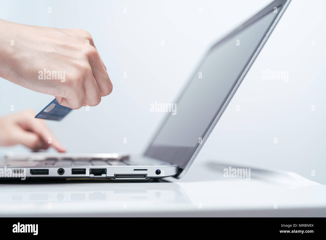 Mains tenant et de carte de crédit à l'aide de l'ordinateur portable. Magasinage en ligne Banque D'Images