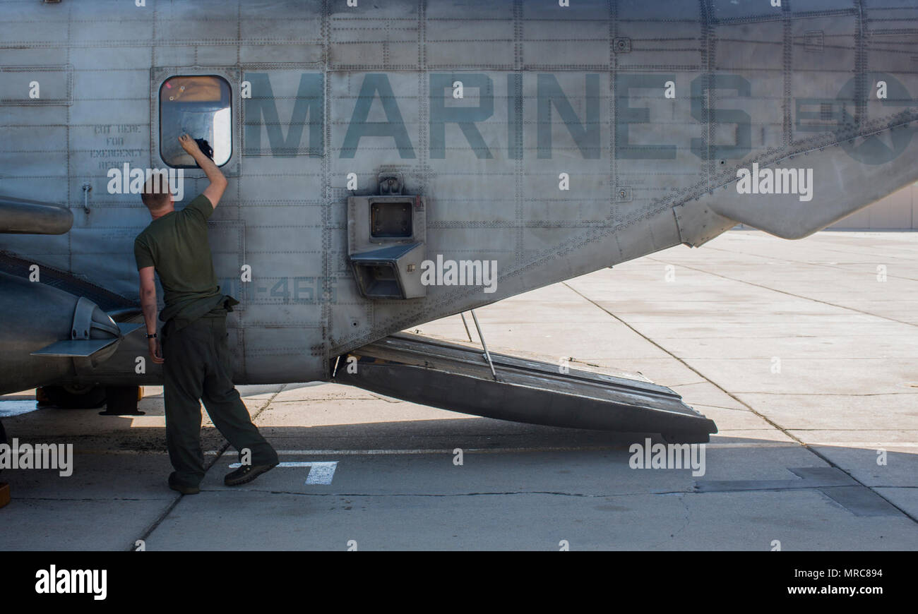 Marine Corps Cpl. Alexander Keegan, une ligne de vol avec l'hélicoptère lourd Mécanicien Marine Escadron (HMH) 466, nettoie la fenêtre d'un CH-53E Super Stallion lors d'armes et tactiques cours instructeurs (WTI) 2-17 au Naval Air Facility El Centro, en Californie, le 14 avril 2017. Le WTI est tenue deux fois par an au Marine Corps Air Station (MCAS) Yuma (Arizona) pour fournir aux étudiants une formation détaillée pour être pratiqué sur les différentes gammes en Arizona et en Californie. Banque D'Images