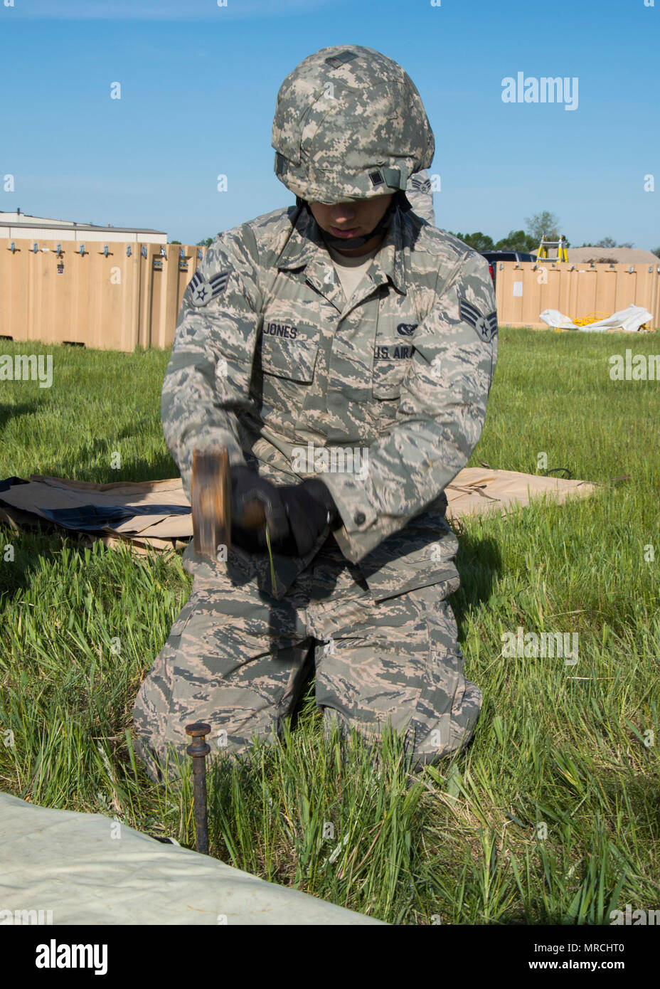 John Jones Senior Airman, 5e Escadron de génie civil, de marteaux apprenti structurels un pieu dans le sol à Minot Air Force Base, N.D., 1 juin 2017. Le 5ème construit ces deux tentes pendant la journée de formation expéditionnaire pour aider à préparer le déploiement potentiel d'aviateurs. (U.S. Air Force photo/Navigant de première classe Alyssa M. Akers) Banque D'Images