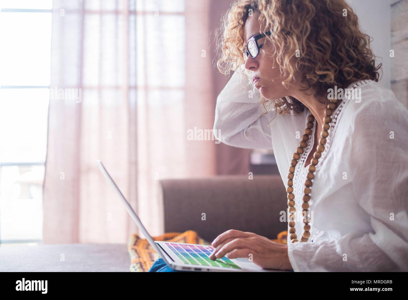 Ennuyé et fatigué caucasian woman les personnes travaillant à la maison avec un ordinateur portable et d'internet. beau modèle liberté faire des affaires sans bureau habituel. Banque D'Images