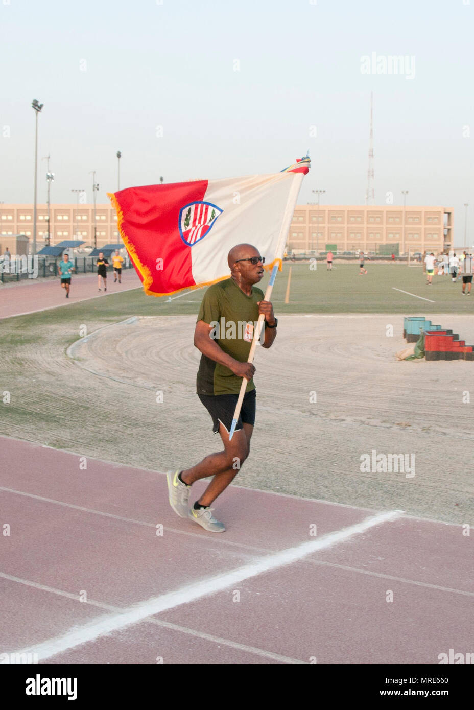 Le sergent-chef. Edgar Ponce, de la 369e Brigade de soutien, porte les couleurs de la brigade sur la ligne d'arrivée dans le premier Harlem Hellfighter 5K, qui s'est déroulée au Camp Arifjan, au Koweït le 2 juin 2017. L'événement a eu lieu pour célébrer le 104e anniversaire de la formation de l'historique de l'unité de la Garde Nationale de New York. L'unité a eu son surnom "Hellfighters historique" par leurs adversaires allemands dans la PREMIÈRE GUERRE MONDIALE pour leurs prouesses remarquables sur le champ de bataille. (U.S. Photo de l'armée par le Sgt. Jeremy Bratt) Banque D'Images