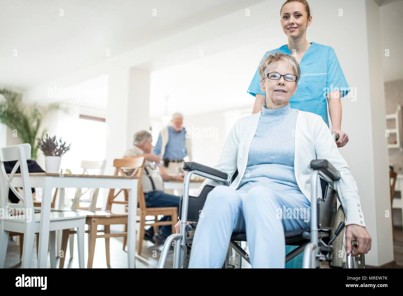 Senior woman in wheelchair with care worker en maison de soins. Banque D'Images