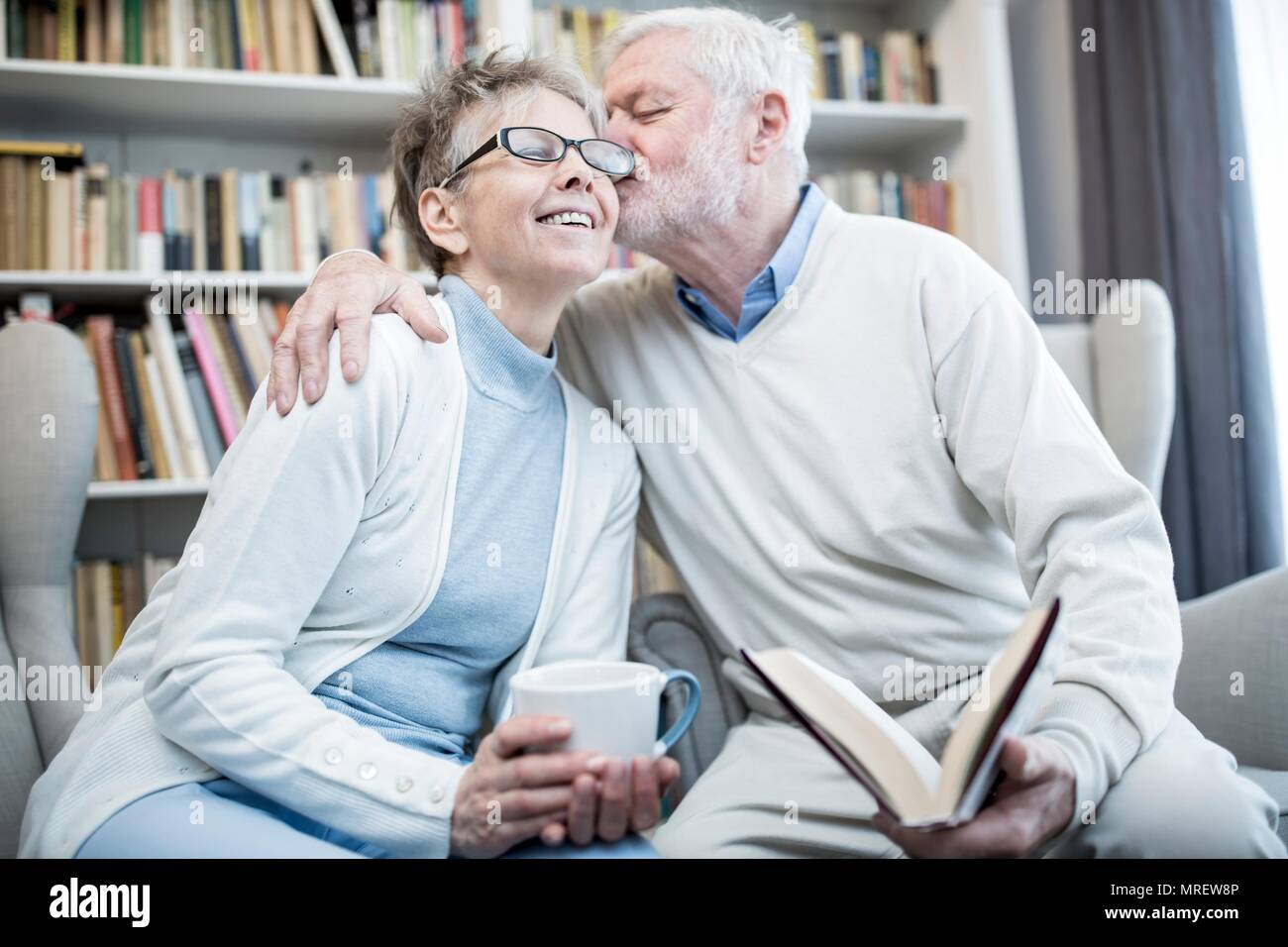 Man kissing woman on joue avec les bras autour d'elle. Banque D'Images