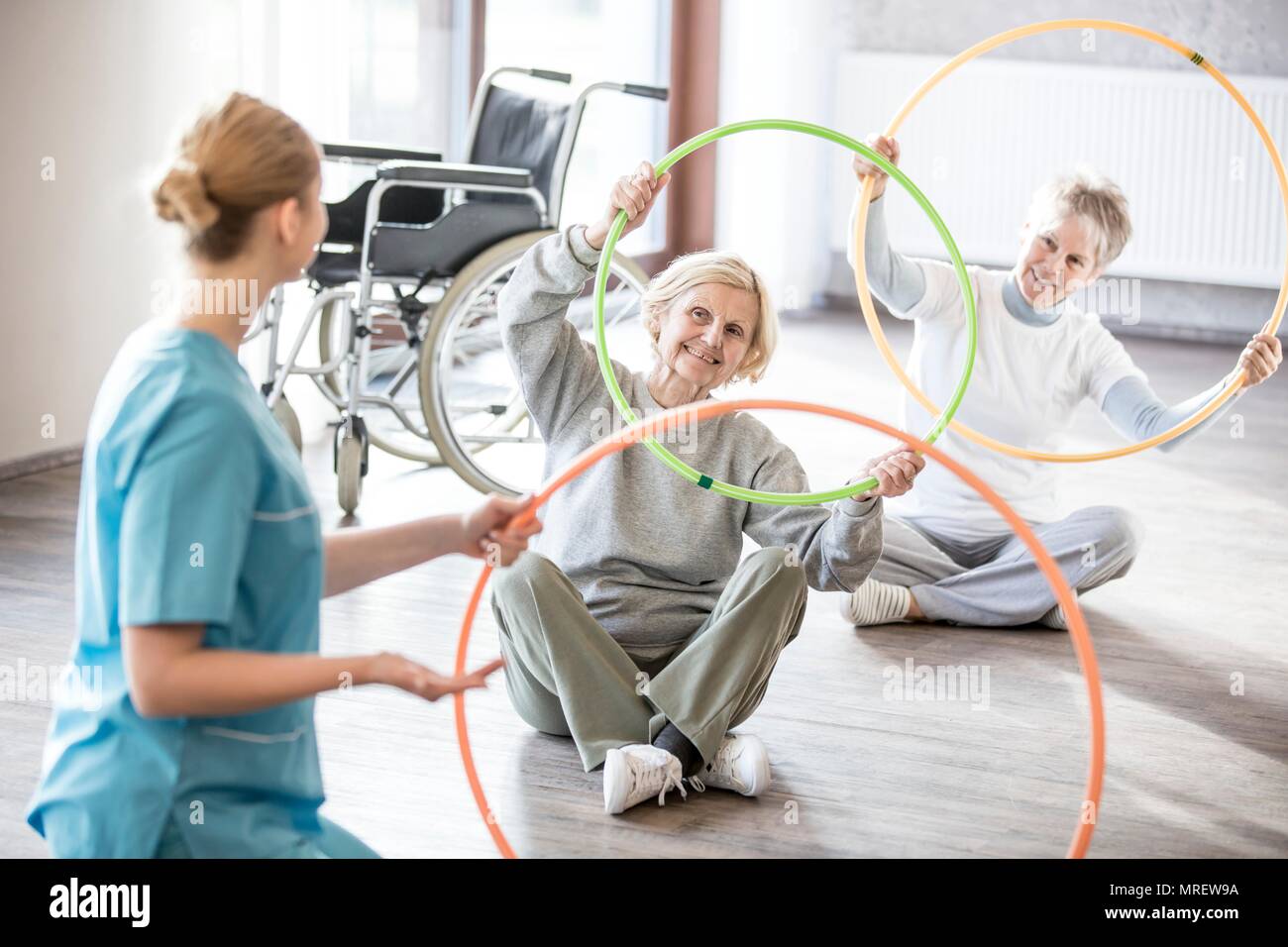 Physiothérapeute avec deux hauts femmes occupant des cerceaux en plastique. Banque D'Images