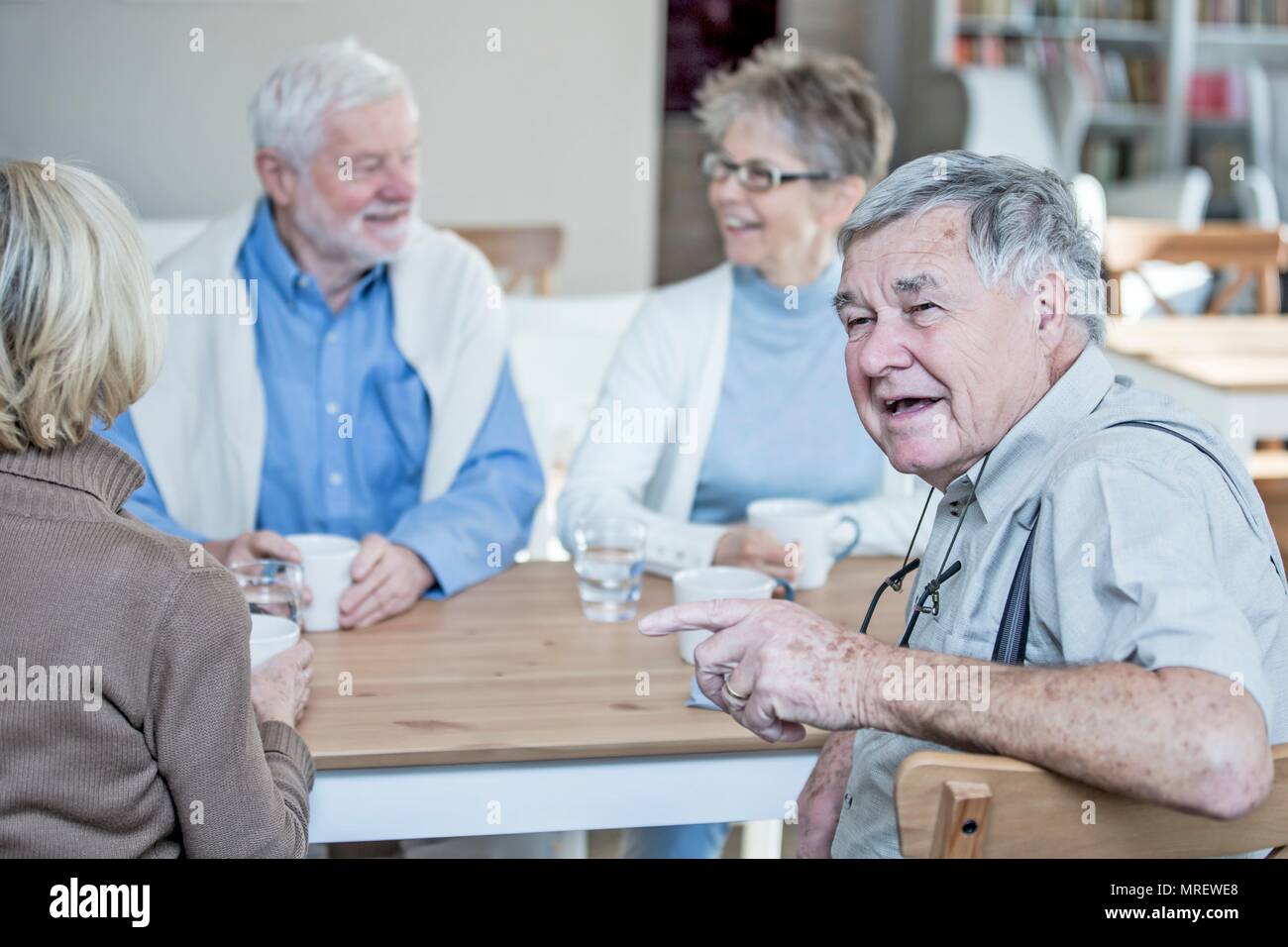 Amis parler et souriant en maison de retraite. Banque D'Images