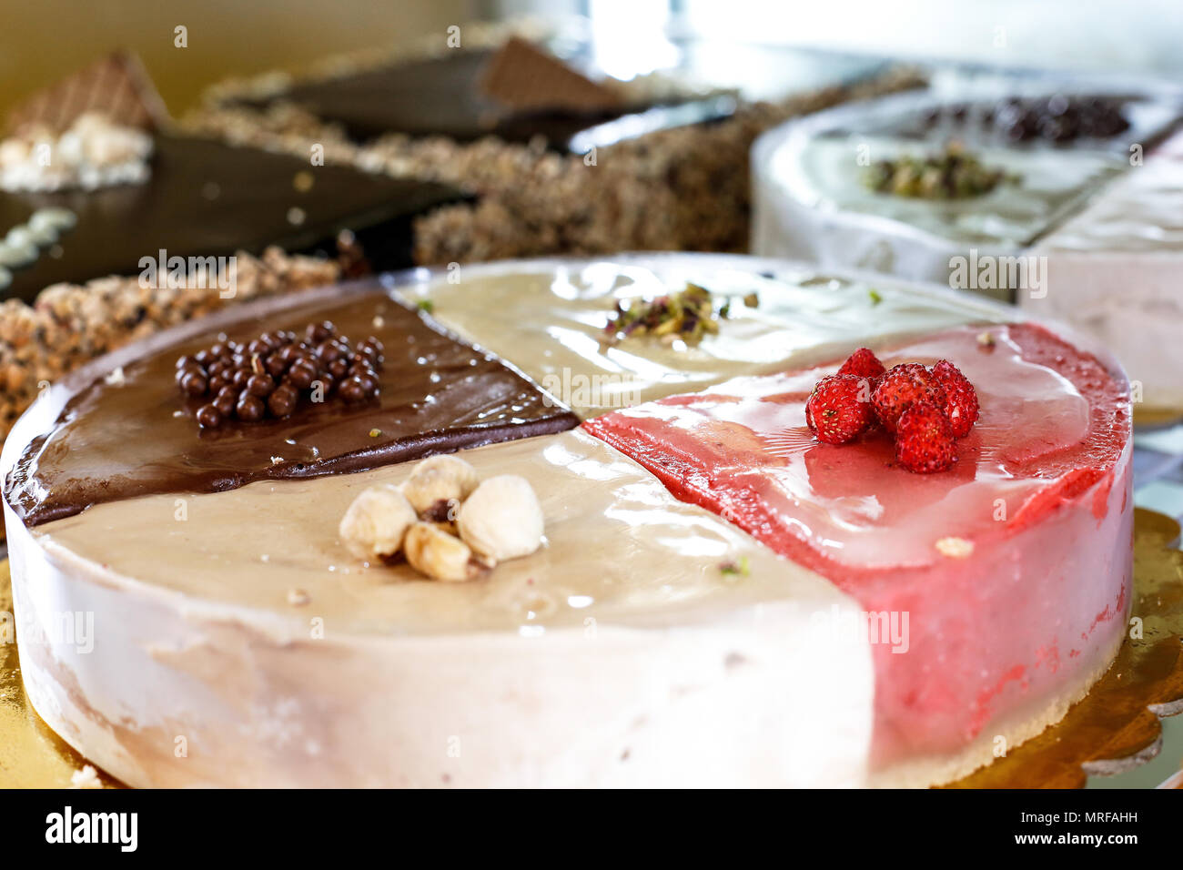 Gâteaux froid, variété de saveurs. Gâteau multicolore divisés en portions : Chocolat, fraise, pistache et noisette Banque D'Images