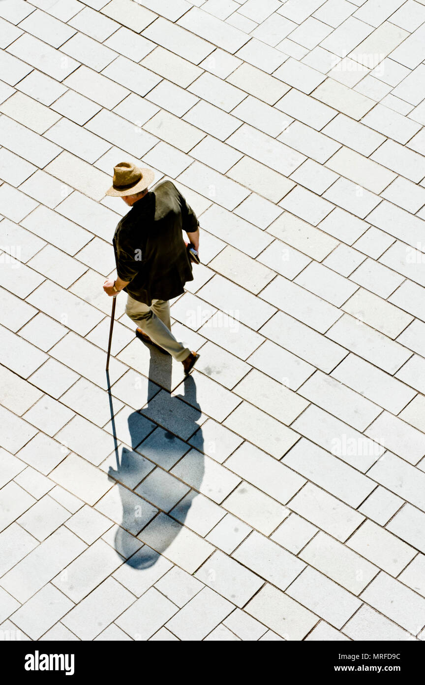 Un homme portant un chapeau de Panama et de marcher avec une canne dans la rue, vue d'en haut Banque D'Images