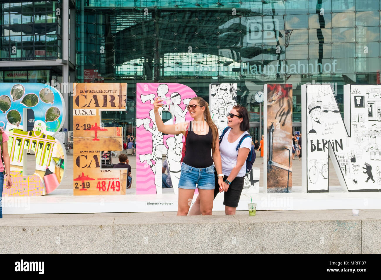 Berlin, Allemagne - mai 2018 : Deux jeunes filles de prendre une photo selfies en face du mot 'Berlin' à la gare principale (Hauptbahnhof Berlin) Banque D'Images