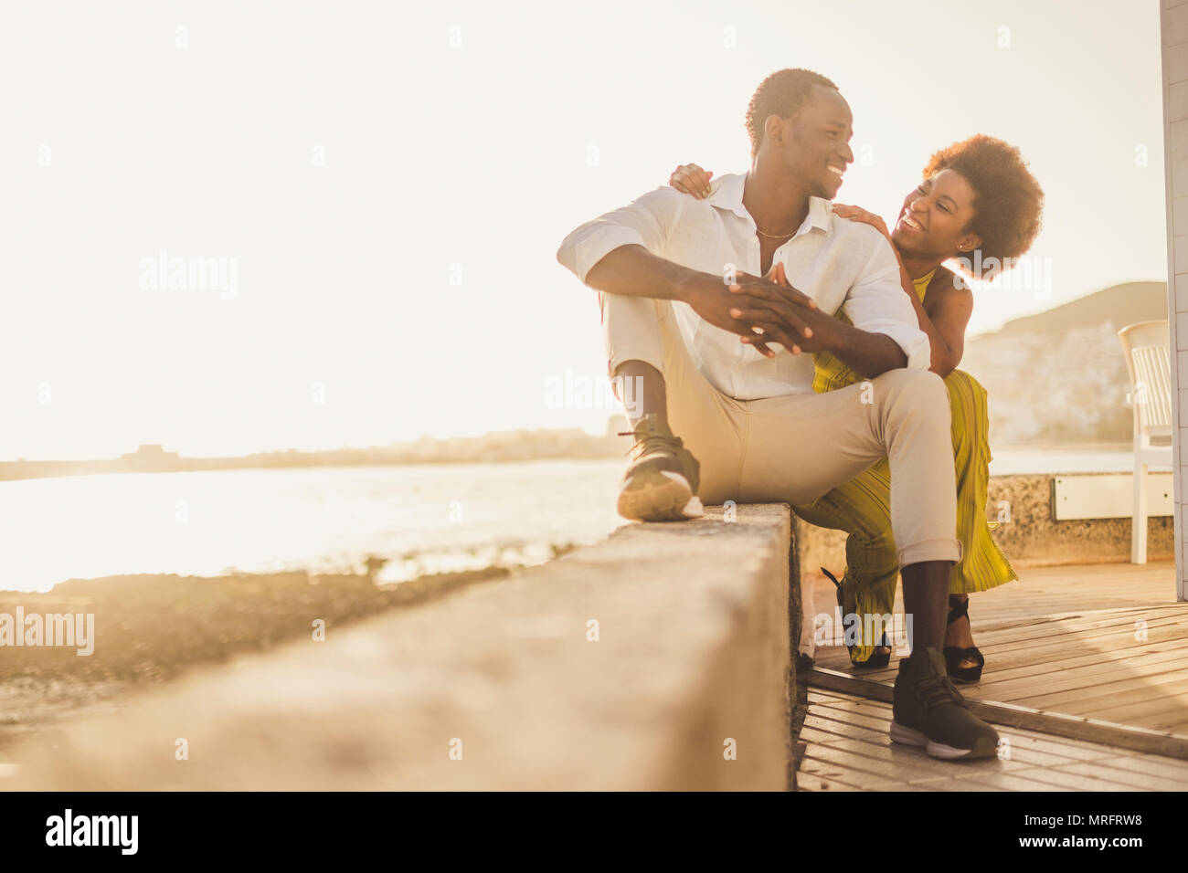 Belle race noire african couple dans l'amour et de vacances bénéficiant d'asseoir ensemble avec de grands sourires et rire. les tenues comme la mode avec style Banque D'Images