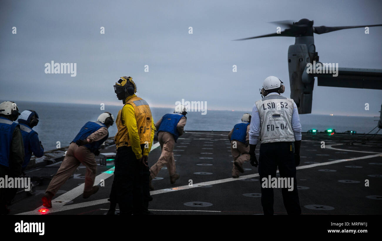 Océan Pacifique - Marines au combat, cargo, 15e Marine Expeditionary Unit et les marins affectés au service du pont à bord du USS Pearl Harbor (LSD 52) exécuter pour supprimer les chaînes de sécurité d'un MV-22B Balbuzard pêcheur sur le pont d'envol du navire au cours de l'exercice de certification, le 5 juin 2017. L'interopérabilité est une compétence essentielle de l'équipe bleu-vert doit avoir des opérations pendant le déploiement. CERTEX est la dernière d'une série d'exercices de formation, qui certifie la MEU-ARG équipe capable d'un déploiement à l'appui de la flotte et les commandants de combat dans toute la gamme des opérations militaires. (U.S. Photo du Corps des marines Banque D'Images