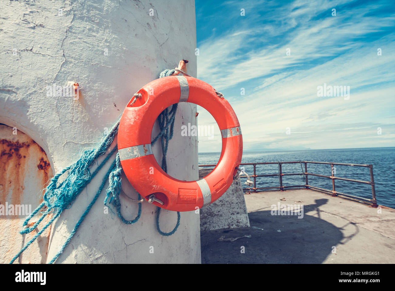 Bouée Orange pendu sur le phare avec ciel bleu et nuages blancs Banque D'Images