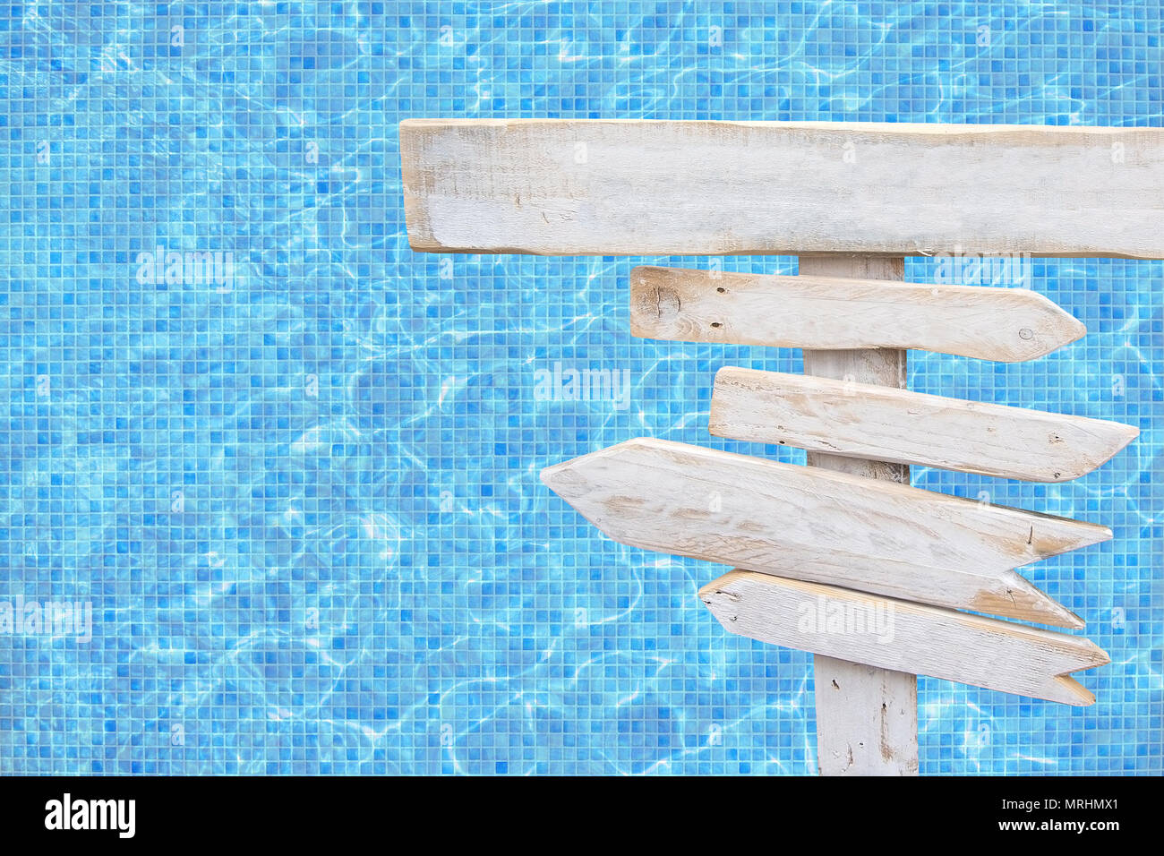 Flèche en bois rustique blanc bleu turquoise plus de signes piscine mosaïque surface de l'eau thème d'été voyage vacances arrière-plan. Banque D'Images
