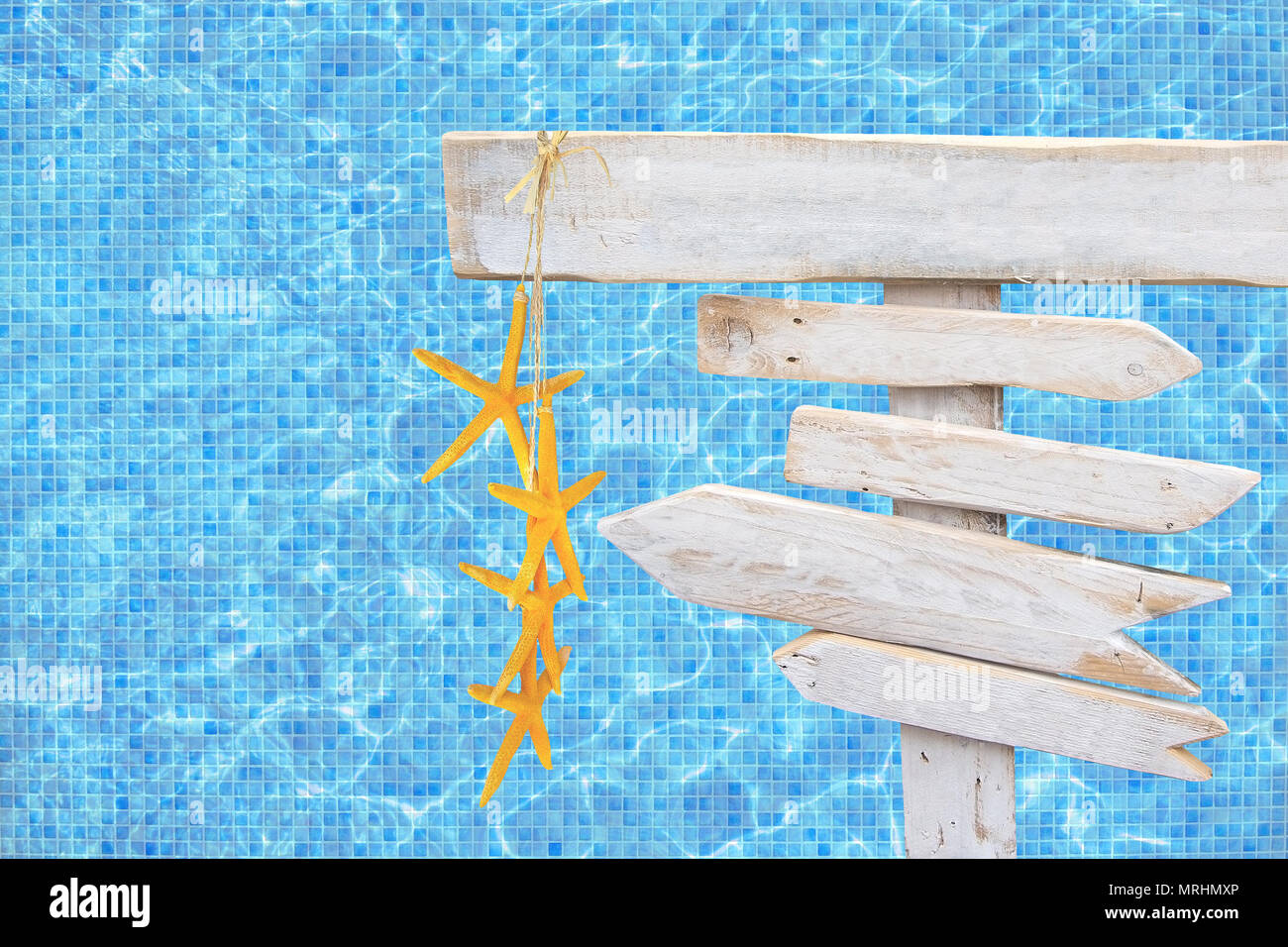 Flèche en bois rustique blanc signe avec l'étoile jaune sur bleu turquoise piscine mosaïque surface de l'eau thème d'été voyage vacances arrière-plan. Banque D'Images