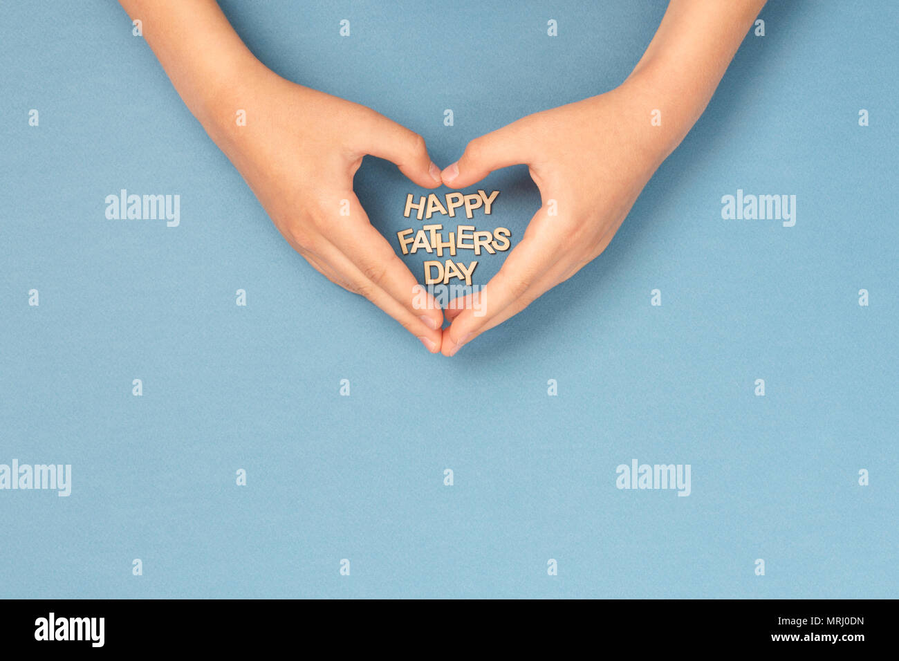 Happy Father's Day card avec mains d'enfant en forme de coeur une woden lettres à l'intérieur. Carte Concept. Banque D'Images