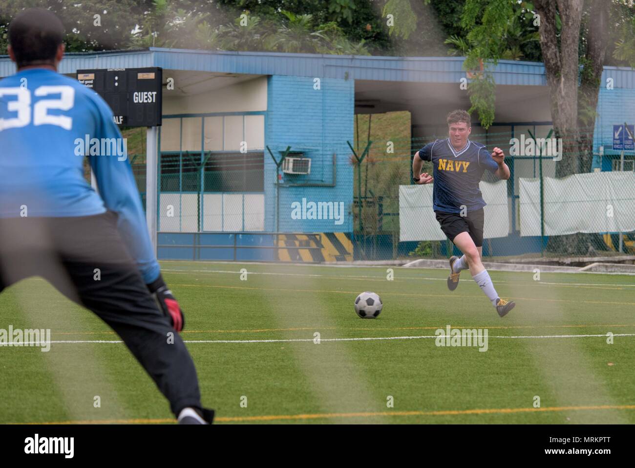 170617-N-OY799-166 Singapour (17 juin 2017) Spécialiste de la communication de masse 2e classe (SW/AW) Nathan Burke, de l'Enterprise, Mississippi, dribble un ballon de foot en bas du champ à une moral, de bien-être et de loisirs (MWR) liens sponsorisés jeu de football contre une équipe locale au cours de la Marine a l'avant-déployé, porte-avions USS Ronald Reagan (CVN 76), escale à Singapour. Les marins affectés à Ronald Reagan a participé à trois jeux de sports parrainés MWR, notamment le soccer, softball et de basket-ball au cours de l'escale à Singapour. Ronald Reagan, le groupe aéronaval du porte-étendard de 5, fournit un contre-r Banque D'Images