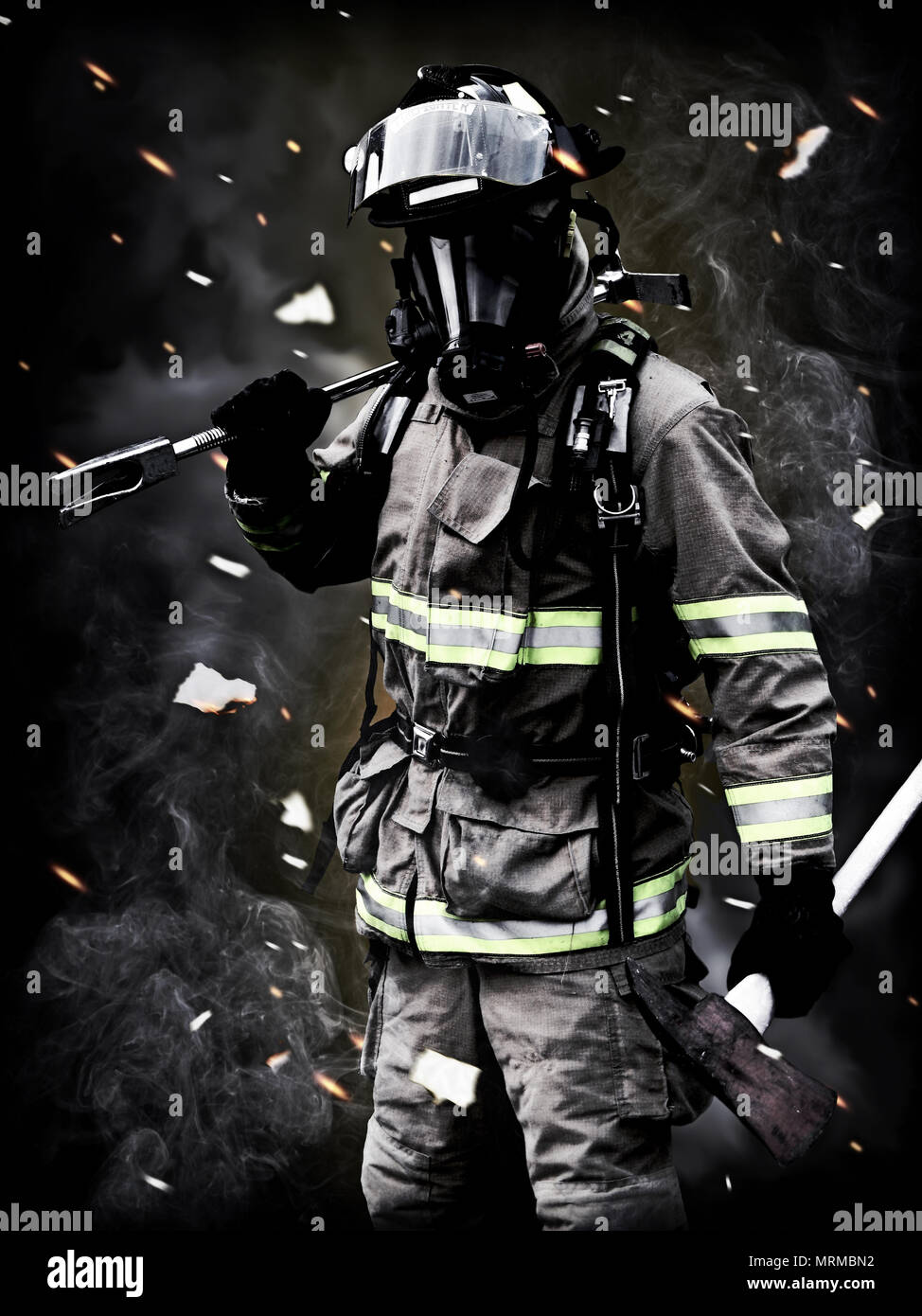 Lendemain , UN pompier pose après une longue lutte incendie avec de la fumée, les débris et les braises dans l'arrière-plan. Banque D'Images