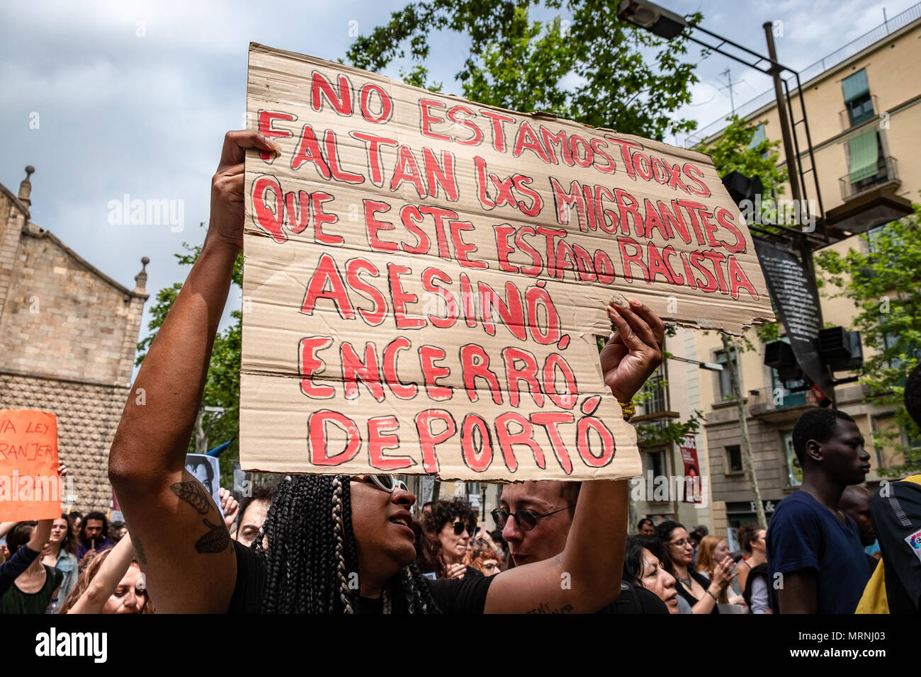 Barcelone, Espagne. 27 mai, 2018. Certains protestataires sont vues montrant un signe avec le texte "Nous ne sommes pas tous. Les migrants sont manquant que l'Etat raciste assassinés, emprisonnés et déportés". Plus de 3 000 personnes ont manifesté dans le centre de Barcelone pour soutenir les personnes qui ont volontairement prendre 37 jours enfermés dans l'école Massana à Barcelone pour demander la nationalité espagnole sans la nécessité de passer des tests de niveau sur la culture et la langue espagnole. La protestation s'étend aussi à la pétition de renverser la loi sur l'immigration et qui réglemente les détentions et expulsions. Credit : SOPA Images Limited/A Banque D'Images