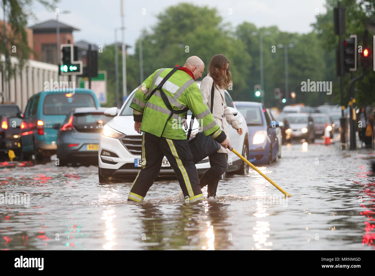Fireman aider une femme traverser une route inondée, Birmingham UK Banque D'Images