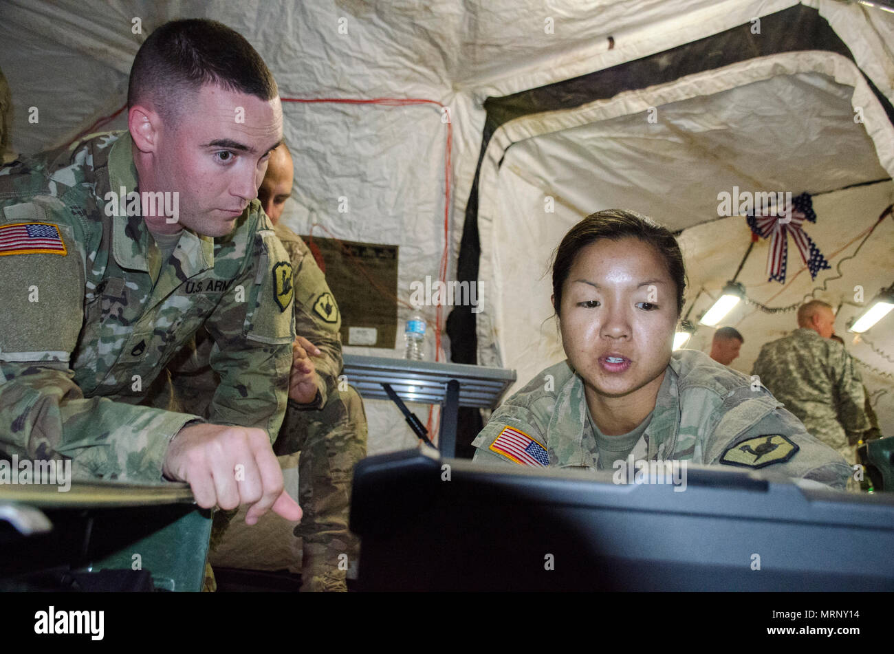 Le s.. Jonathan Sims, un spécialiste en soutien des systèmes d'information avec la 158e Brigade d'amélioration de Manœuvre et le Cpl. Anna Sarmiento, un Nœud de réseau mixte, l'opérateur avec le 365e compagnie de transmissions, vérifier la liaison de données sécurisé entre le signal company et la BAM. Le 365e a été la réalisation de la formation annuelle à l'appui de la BAM à Camp Navaho, Arizona), 3-17 juin. (Arizona) La Garde nationale de l'armée photo par le Sgt. 1re classe Robert Freese) Banque D'Images