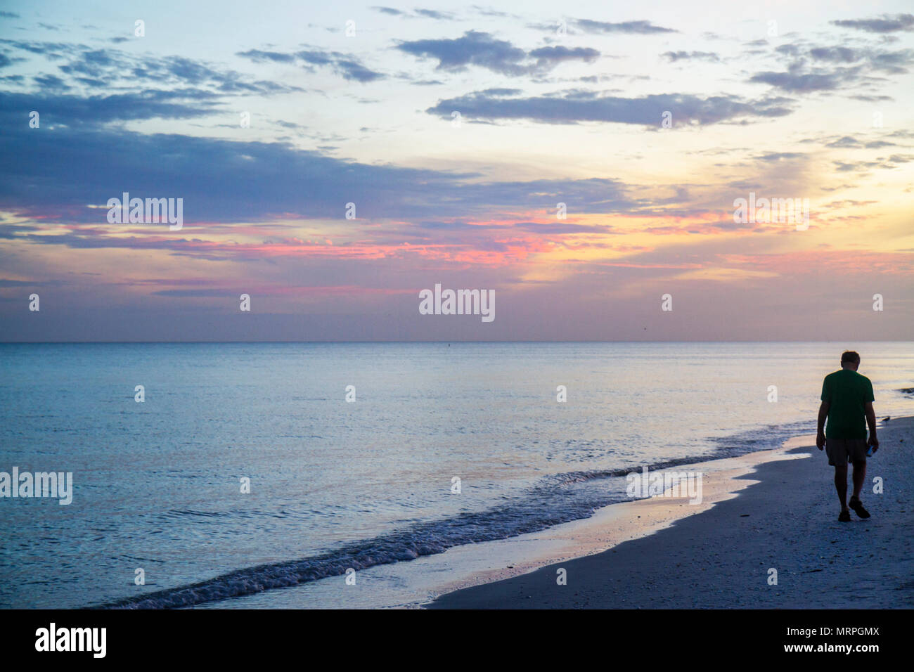 Floride Sanibel Barrier Island, Golfe du Mexique, coucher de soleil, plage de sable plages de l'eau ciel, vagues de surf, les combres de plage, les visiteurs Voyage voyage touristique Banque D'Images