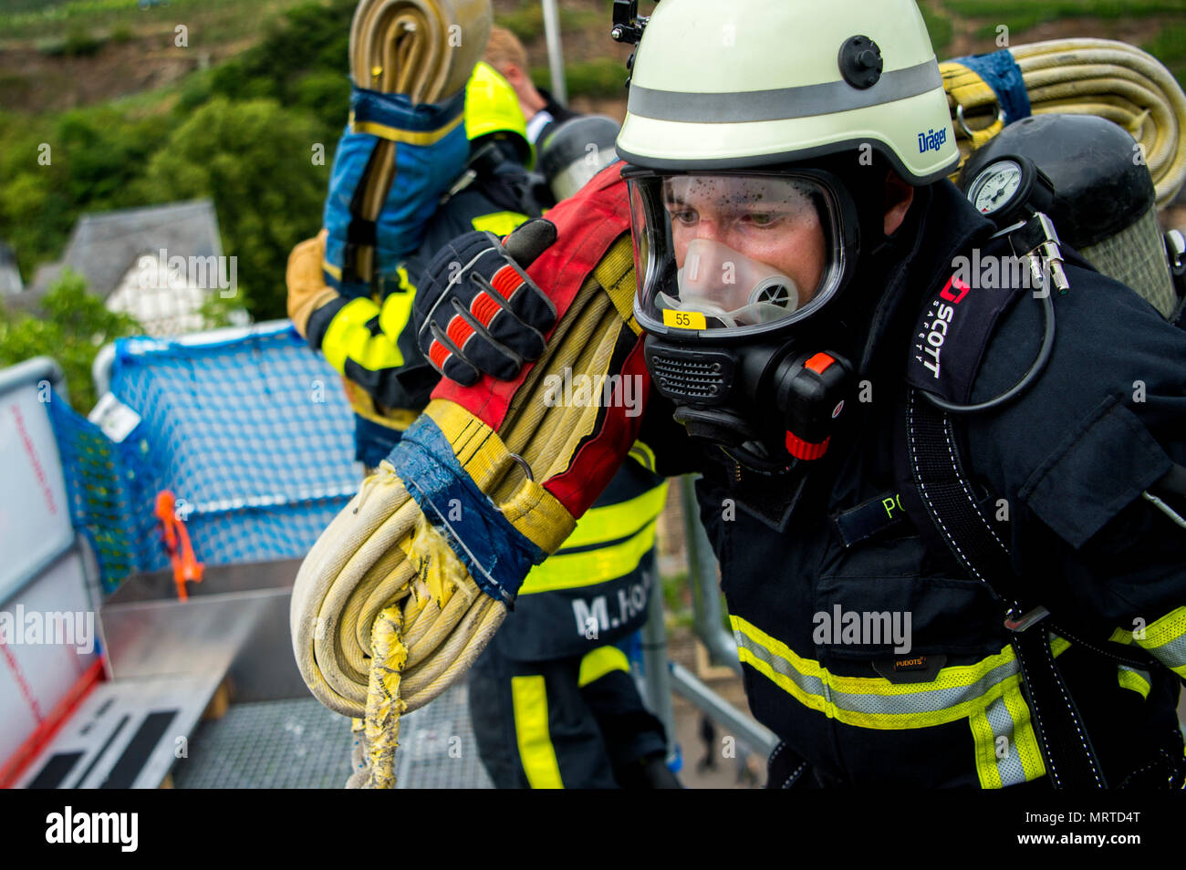 Un pompier de l'Allemagne porte un flexible pendant la course contre un  adversaire au cours de la 4e conférence annuelle de Mosel Firefighter  Combat Challenge dans Alf, Allemagne, le 30 juin 2017.