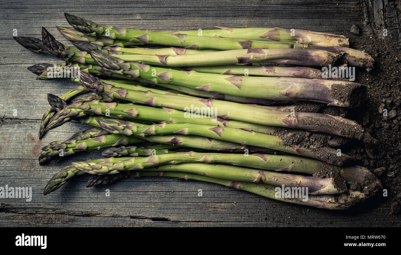 Au-dessus de coup de frais vert asperges sur table en bois avec heap de sol Banque D'Images
