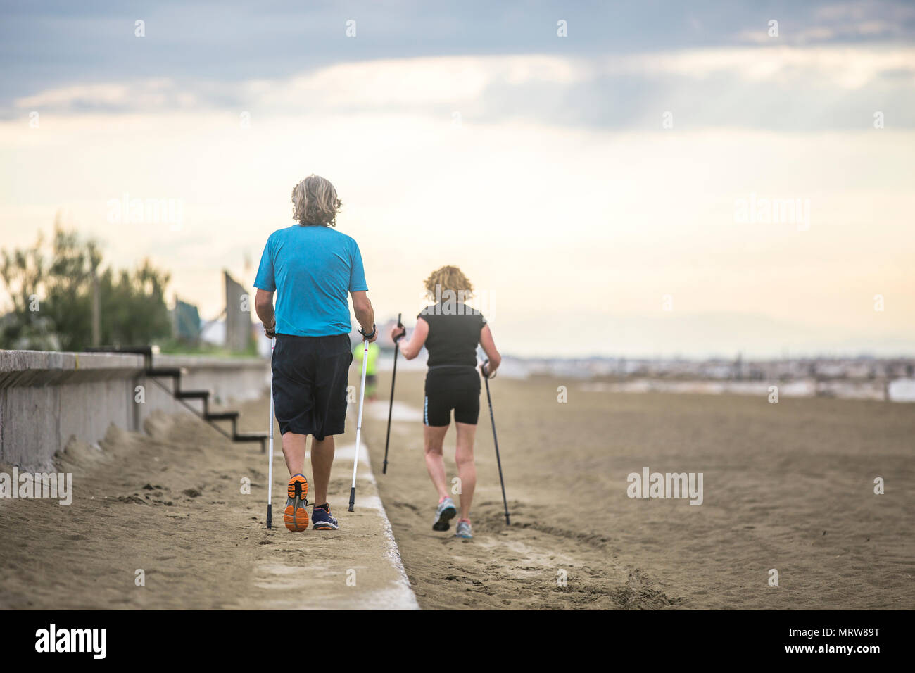 Senior couple nordic waling sur la plage. Banque D'Images