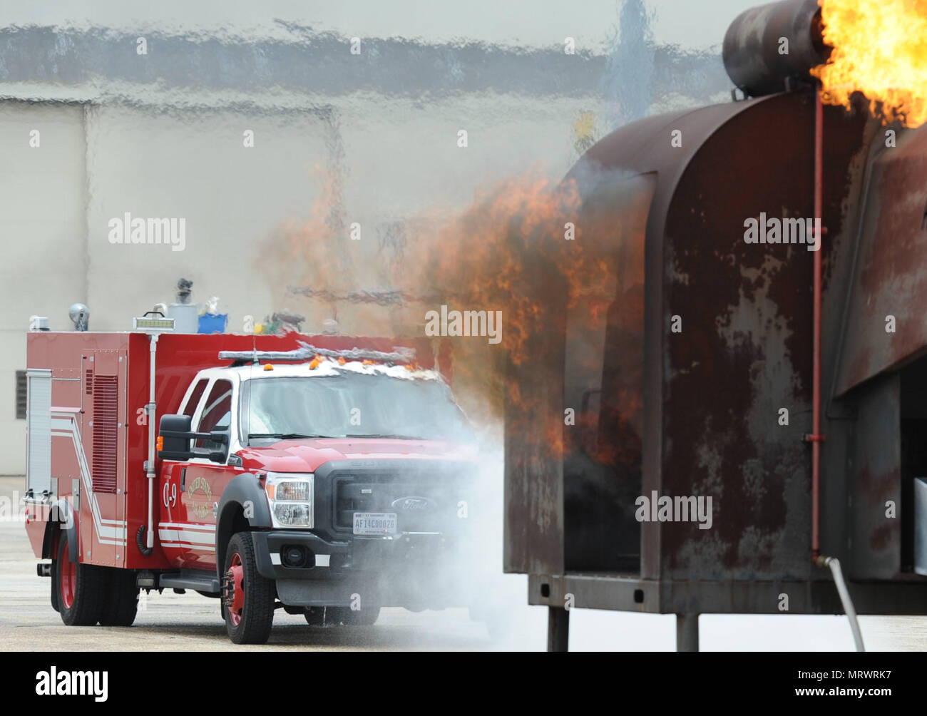 Les pompiers de Keesler utiliser un camion d'incendie sur un flexible de la tourelle d'aides à la formation de pompier pendant un exercice de tir réel sur la piste le 6 juin 2017, sur la base aérienne de Keesler, mademoiselle l'incendie, le ministère de Keesler Gulfport CRTC Fire Department et le service d'incendie de Stennis Space Center sont tous nécessaires à la pratique service de Sauvetage et lutte contre les incendies pour répondre à une exigence de formation semi-annuel. (U.S. Air Force photo par Kemberly Groue) Banque D'Images