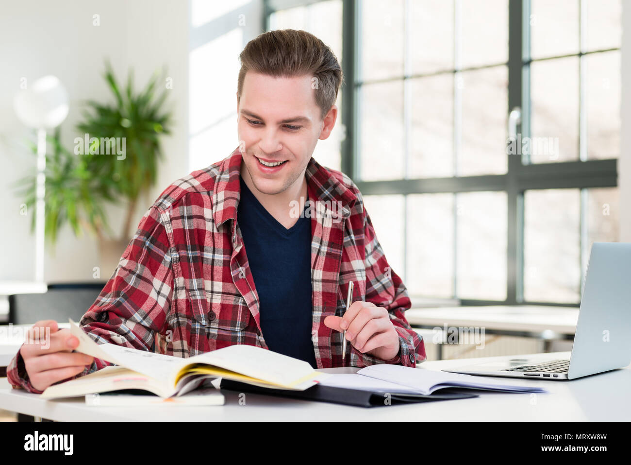 Portrait of a young student smiling tandis que la recherche d'informations Banque D'Images