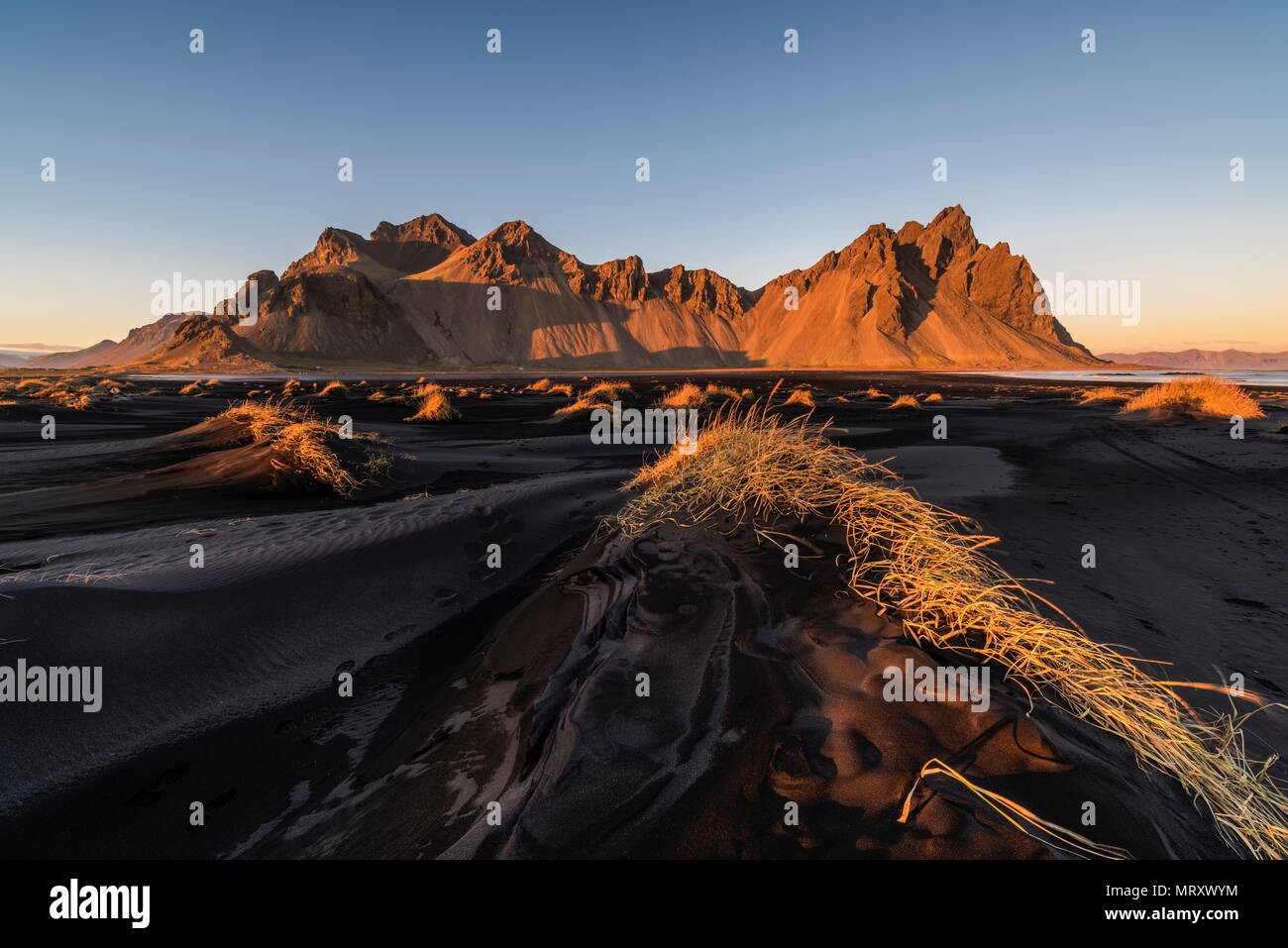 Stokksnes, Hofn, Islande, Islande de l'Est. La montagne noire et le Vestrahorn dunes de sable au coucher du soleil. Banque D'Images