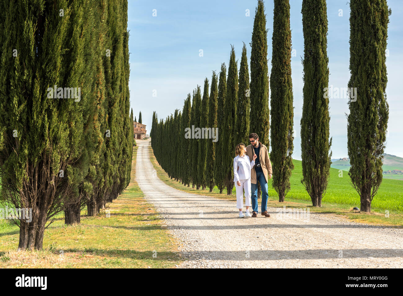 Castiglione d'Orcia, Val d'Orcia, Sienne, Toscane, Italie. Un couple en train de marcher le long d'une route de campagne Banque D'Images