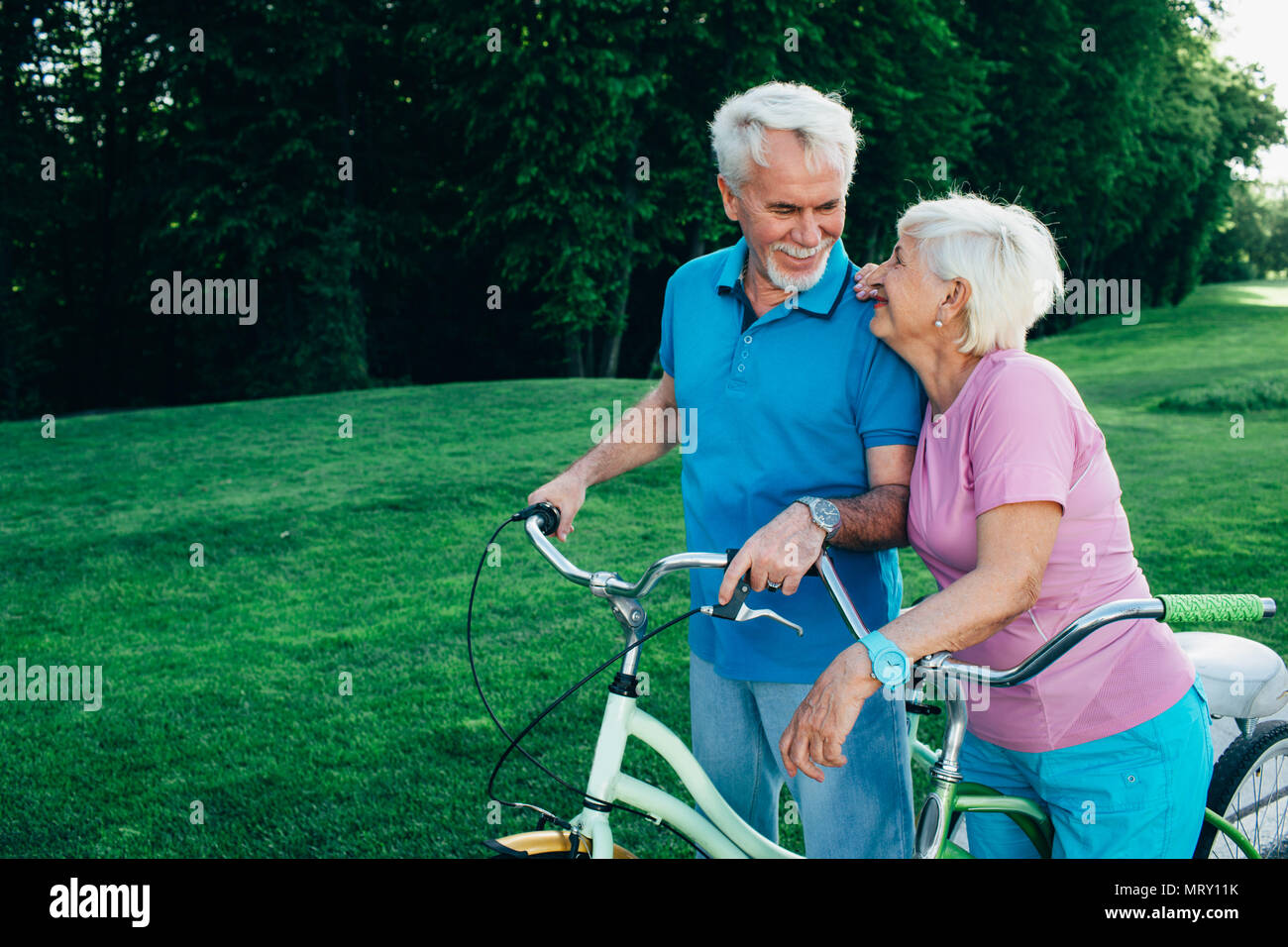 Senior couple allant pour une balade à vélo dans le parc Banque D'Images