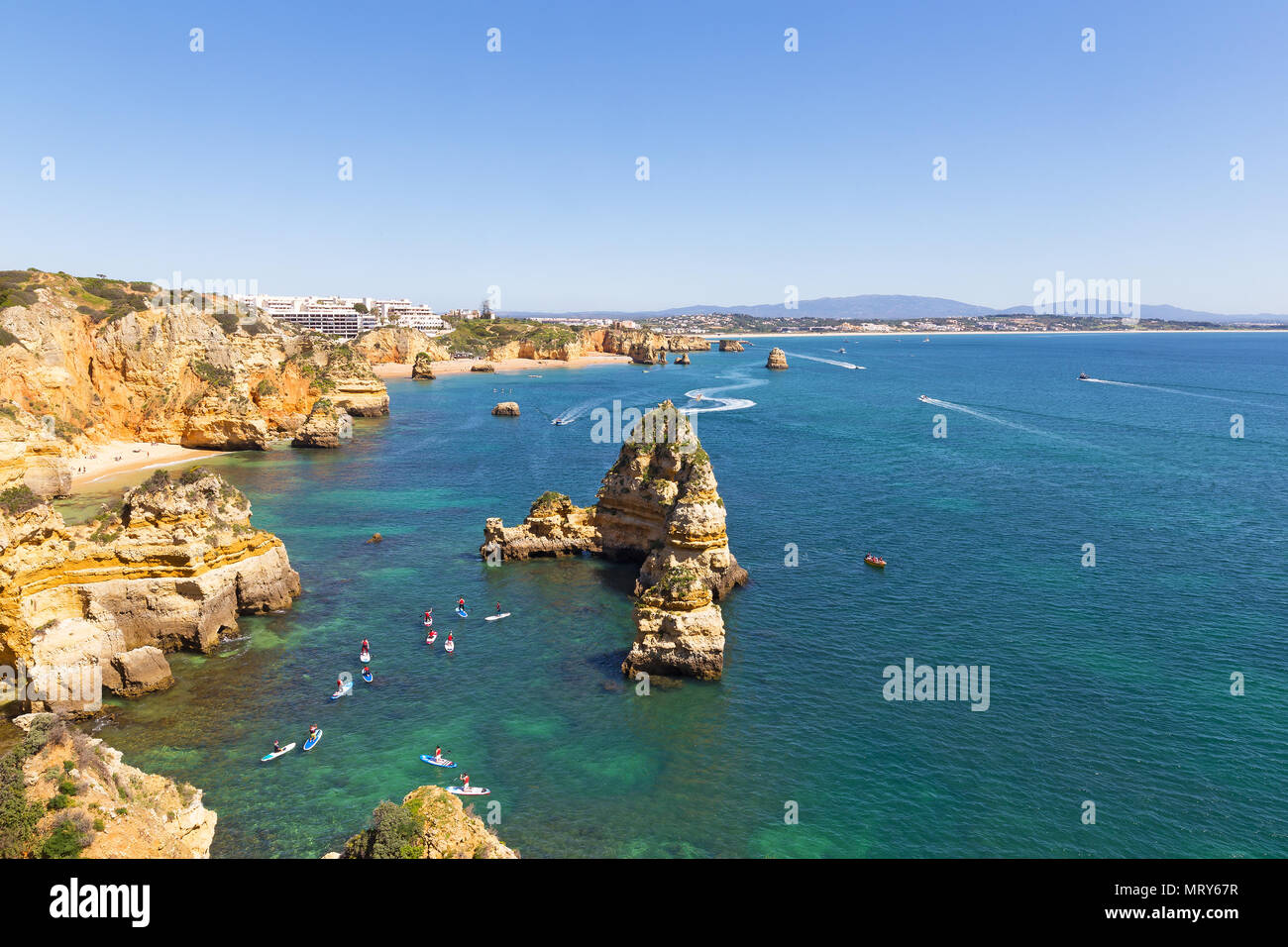 Grottes et falaises pittoresques explorer par les touristes par des kayaks et bateaux en Algarve, Portugal. Côte pittoresque avec des plages de sable et des activités nautiques Banque D'Images